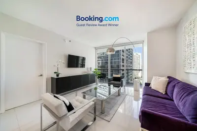 a living room with a purple couch and a table at Incredible Ocean View 1BR 1BA Icon Brickell in Miami