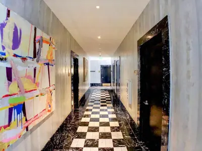 a hallway with a checkered floor and paintings on the walls at Incredible Ocean View 1BR 1BA Icon Brickell in Miami