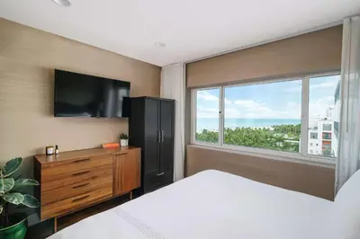 a bedroom with a bed and a tv and a window at Nautilus Sonesta Miami Beach in Miami Beach