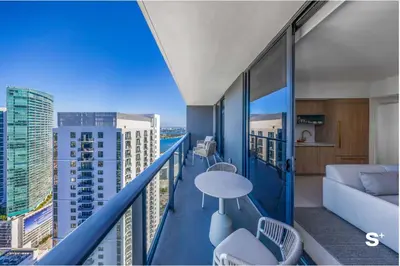 a balcony with a couch and a table and chairs at Contemporary 2-BD Condo in Downtown Miami - Skyline & Ocean Views in Miami