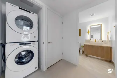 a white washing machine in a bathroom with a sink at Contemporary 2-BD Condo in Downtown Miami - Skyline & Ocean Views in Miami