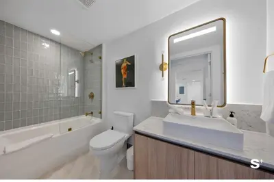 a bathroom with a sink and a tub and a toilet at Contemporary 2-BD Condo in Downtown Miami - Skyline & Ocean Views in Miami