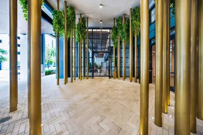 a hallway with gold columns and plants in a building at Contemporary 2-BD Condo in Downtown Miami - Skyline & Ocean Views in Miami