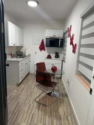 a kitchen with white cabinets and a table and chairs at Villa Clara Red-Little Havana in Miami