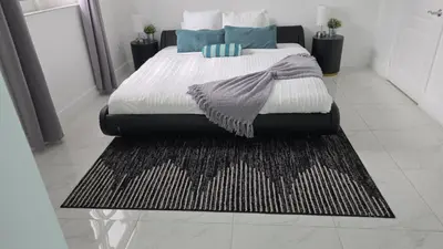 a bedroom with a large bed with a rug at Exclusivity & Relaxation Offered By Our Condo in Miami
