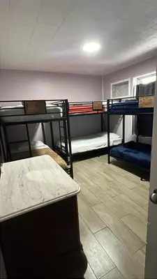 a room with three bunk beds and a table at Bed in 6-Bed Dormitory Room in Miami