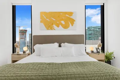a bedroom with a large bed and two windows at On 44th Floor! Condo w The Best Views & Free Parking in Miami