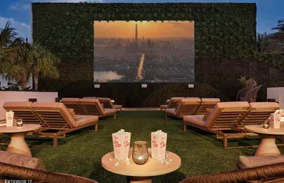a patio with chairs and tables and a large screen at Stunning High-Floor City View 1BR Hyde Beach House in Hollywood