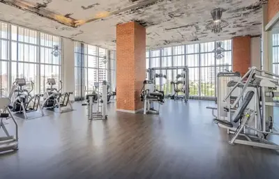 a gym with treadmills and machines in a room with windows at Stunning High-Floor City View 1BR Hyde Beach House in Hollywood