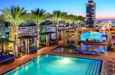 a view of a rooftop pool on a building with palm trees at Beautiful Hyde Resort Luxe 2BR Private Beachfront in Hollywood