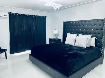 a bedroom with a large bed with a black headboard at Best Location!! in Miami