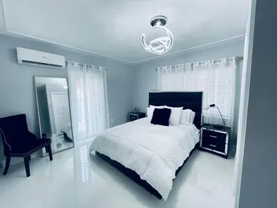 a white bedroom with a bed and a chair at Best Location!! in Miami