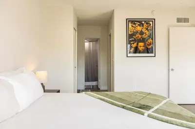 a white bedroom with a white bed and a picture on the wall at 1BR with Kitchen Eastern Shores near Sunny Isles in North Miami Beach