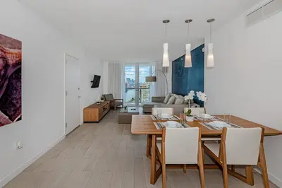a dining room and living room with a table and chairs at 2 Bed 2 Bath at Beachwalk With Pool Gym Beach in Hallandale Beach