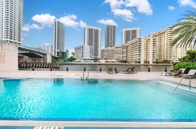 a large swimming pool with a city skyline in the background at Beachwalk 2 Bedrooms & Kitchen in Hallandale Beach