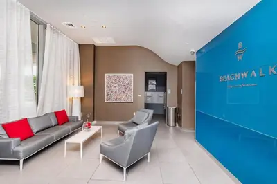 a living room with a couch and two chairs at Amazing Studio at Beachwalk with Pool & Gym in Hallandale Beach