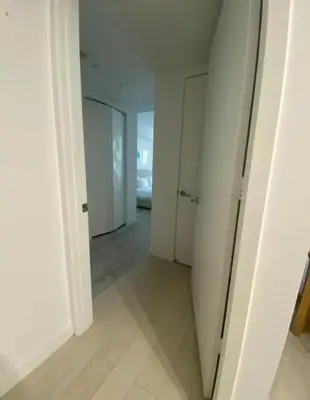 an empty hallway with white walls and white doors at 2 Bed 2 Bath Full Equiped Beachwalk Pool Gym 22 in Hallandale Beach