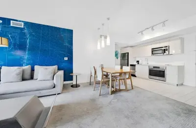 a living room with a couch and a table at 1 Bed & Kitchen at Beachwalk Luxe Pool Gym Beach in Hallandale Beach