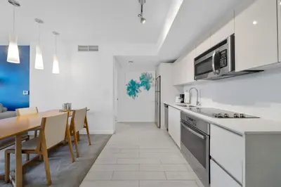 a kitchen with white walls and a table and chairs at 2 Bed & 2 Bath at Beachwalk Pool Gym Beach on 19th in Hallandale Beach