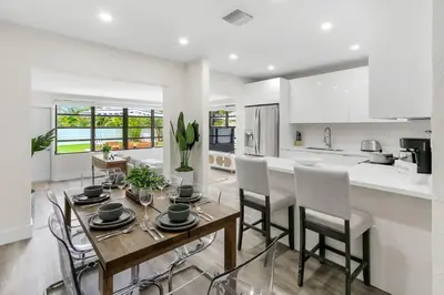 a kitchen and dining room with a table and chairs at Charming 4BR Oasis with Saltwater Pool and Parking in North Miami