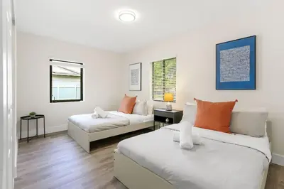 a living room with two beds and a couch at Charming 4BR Oasis with Saltwater Pool and Parking in North Miami