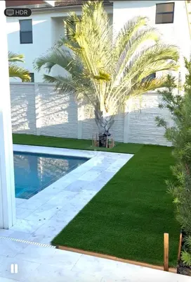 a swimming pool with a palm tree next to a house at Cozy house in Goulds
