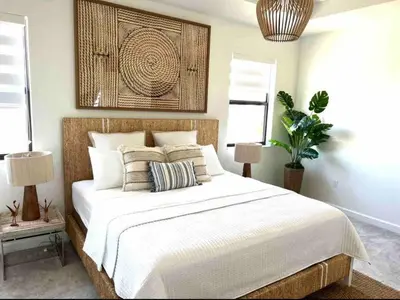 a bedroom with a large white bed with two lamps at Cozy house in Goulds