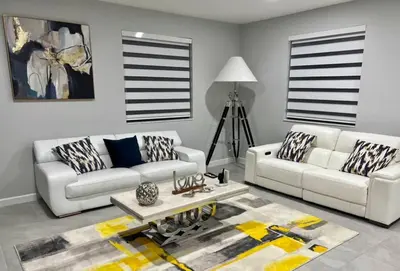 a living room with two white couches and a table at Cozy house in Goulds