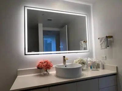 a bathroom with a sink and a large mirror at Luxury Ocean Views Apt in Hallandale Beach in Hallandale Beach