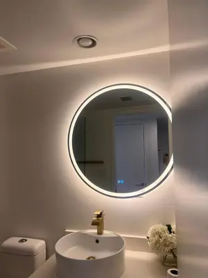 a bathroom with a round mirror and a sink at Studio Luxury Ocean Views Apt in Hallandale Beach in Hallandale Beach