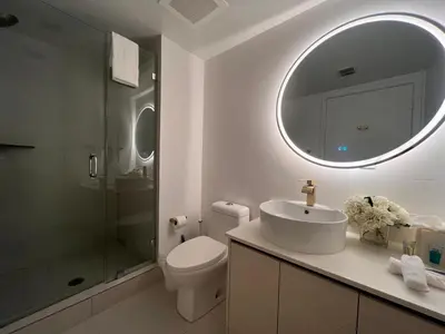 a bathroom with a toilet and a sink and a mirror at Studio Luxury Ocean Views Apt in Hallandale Beach in Hallandale Beach