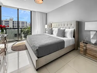 a bedroom with a large bed and a large window at Bay Breeze Premium Apartments by Eskape Collection in Miami Beach