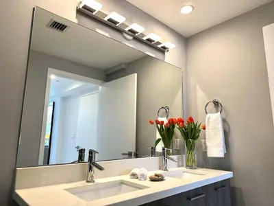 a bathroom with two sinks and a large mirror at Bay Breeze Premium Apartments by Eskape Collection in Miami Beach