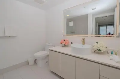 a bathroom with a sink and a toilet and a mirror at 2B 2B Luxury Ocean Views Apt in Hallandale Beach in Hallandale Beach