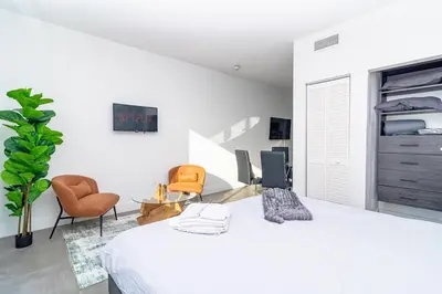 a white bedroom with a bed and chairs at Urban Oasis in Miami Close to Bayside and Brickell with Free Parking in Miami
