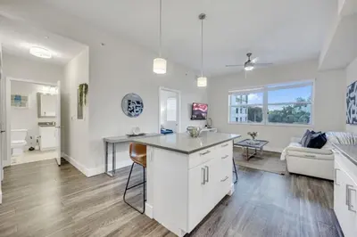 a kitchen and living room with a table and a couch at Trendy One Bedroom Getaway Steps from Biscayne in Miami