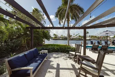 a patio with a couch and chairs and a pool at Palm Pointe - One third of a mile to the beach - Heated Pool - Intracoastal Views in Fort Lauderdale