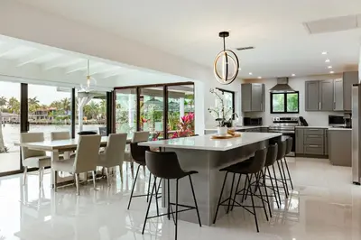 a kitchen and dining room with a large table and chairs at Palm Pointe - One third of a mile to the beach - Heated Pool - Intracoastal Views in Fort Lauderdale