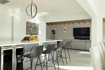 a kitchen with a bar with chairs and a television at Palm Pointe - One third of a mile to the beach - Heated Pool - Intracoastal Views in Fort Lauderdale