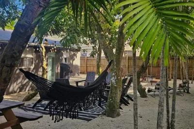 a hammock in a courtyard with trees and benches at Casa Eden - Half mile to Lauderdale Marine Center - 4 bedrooms - 2 bathrooms in Fort Lauderdale
