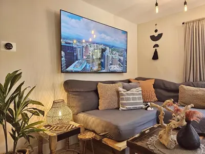 a living room with a couch and a tv on the wall at Casa Eden - Half mile to Lauderdale Marine Center - 4 bedrooms - 2 bathrooms in Fort Lauderdale