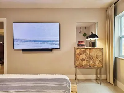 a bedroom with a flat screen tv on the wall at -Disco Bungalow- One third mile to FTL Marine Center in Fort Lauderdale