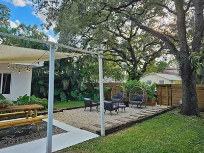 a patio with chairs and a bench and a tree at -Disco Bungalow- One third mile to FTL Marine Center in Fort Lauderdale