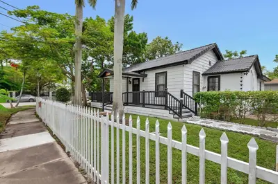 a white picket fence in front of a white house at Casa Del Sol Cozy 2br Retreat 10 Mins To Beach in Miami