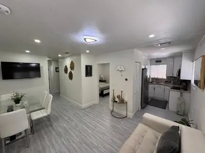 a living room with a couch and a table and a kitchen at Stylish 2 Bedrooms Apartment by Miami Airport in Miami