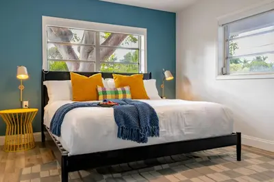 a bedroom with a bed with blue walls and a window at Stunning 8 bedroom Villa with Pool Basketball Pickleball BBQ Mini-golf and more in North Miami