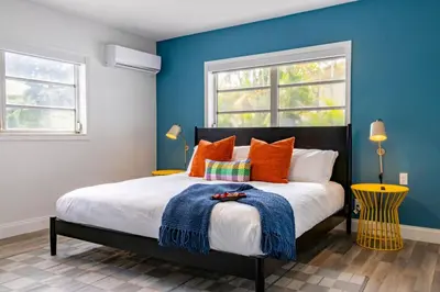 a bedroom with blue walls and a bed with orange pillows at Stunning 8 bedroom Villa with Pool Basketball Pickleball BBQ Mini-golf and more in North Miami