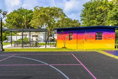 a building with a basketball court in a park at Stunning 8 bedroom Villa with Pool Basketball Pickleball BBQ Mini-golf and more in North Miami