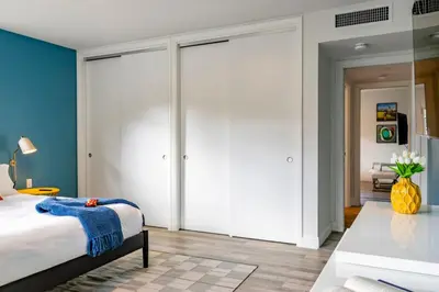 a bedroom with white sliding doors and a bed at Stunning 8 bedroom Villa with Pool Basketball Pickleball BBQ Mini-golf and more in North Miami