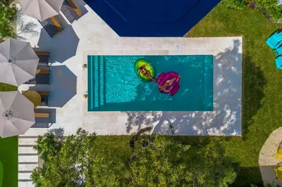 an overhead view of two people in a swimming pool at Stunning 8 bedroom Villa with Pool Basketball Pickleball BBQ Mini-golf and more in North Miami
